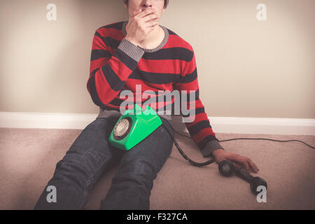 Shocked man covering his mouth after telephone call Stock Photo