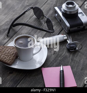 Analogue photo camera on a table with coffee and paper notes Stock Photo