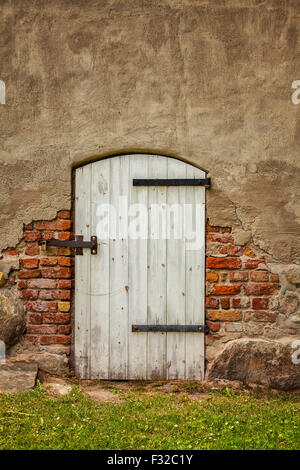 Image of an old white barn type door in a bricked building. Stock Photo