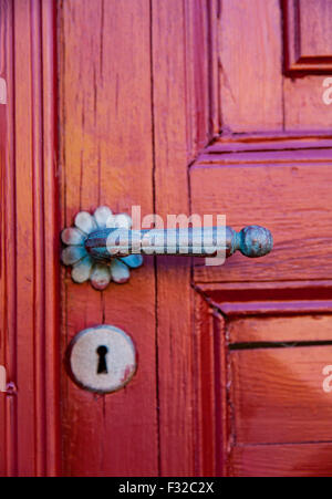 Image of a red door with ornate bronze handle. Shallow depth of field. Stock Photo