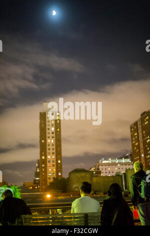 New York, USA. 28th Sep, 2015. Hundreds of people gather on the High Line Park in New York to view the supermoon lunar eclipse on Sunday, September 27, 2015. The combination of a supermoon, the moon is closest to the Earth, and a total lunar eclipse is extremely rare and won't occur again until 2033. Credit:  Richard Levine/Alamy Live News Stock Photo