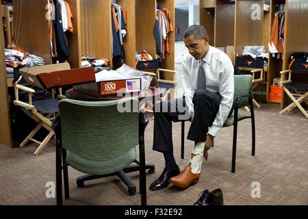 U.S. President Barack Obama tries on a pair of cowboy boots at the University of Texas August 9, 2010 in Austin, Texas. Stock Photo