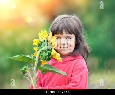 Little girl with sunflower outdoors Stock Photo