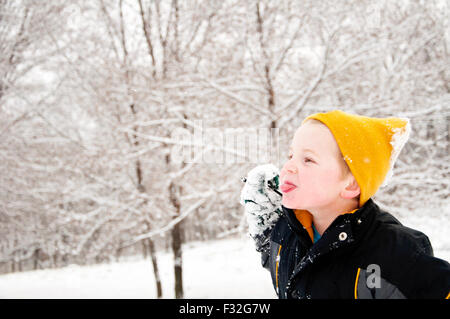 Boy sticking out tongue winter landscape Stock Photo