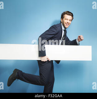 Elegant young man running with the commercial board Stock Photo