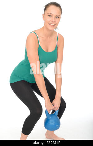 Attractive Sporty Young Woman Working Out To Keep Fit And Tone Her Body Lifting a 5kg Kettle Bell Weight Isolated Against A White Background Stock Photo