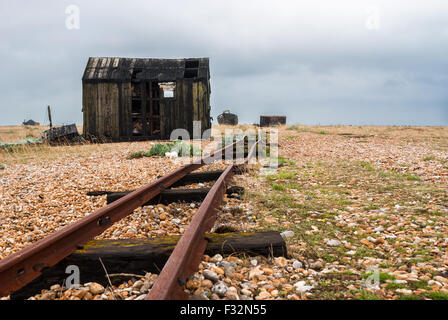 Abandoned hut left to rot and decay on the beach at Dungeness, Kent. A grey, moody sky adds to the sad  scene Stock Photo