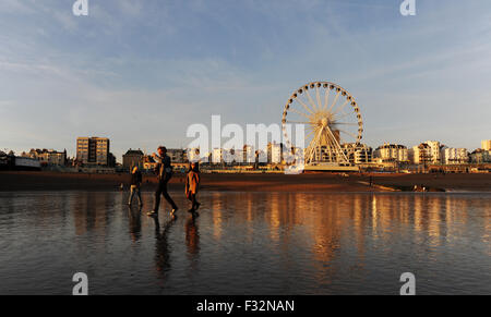 Brighton, UK. 28th September, 2015. UK Weather: People enjoy the unusually low tide at sunset on Brighton seafront tonight as the usually covered sand reveals itself along the coast after a warm sunny day of weather  Credit:  Simon Dack/Alamy Live News Stock Photo
