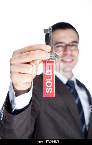 Realtor Holding Up Old Key with Red SOLD Sign Stock Photo