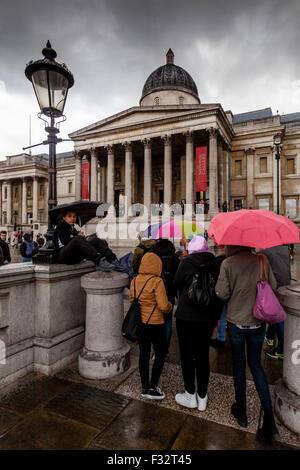 Visitors Standing Outside The National Gallery In The Rain, London, UK Stock Photo