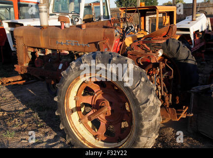 Rusted farm tractor parts in junkyard at sunset,US,2015. Stock Photo