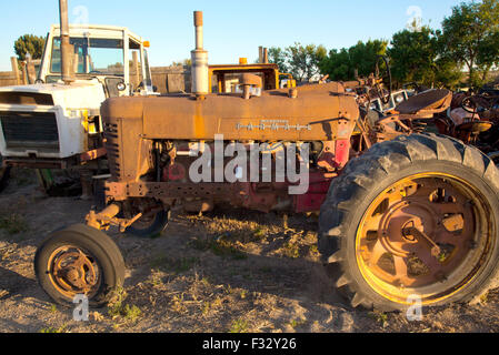 Rusted Farmall farm tractor in junkyard at sunset,US, 2015. Stock Photo