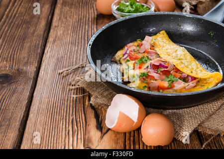 Frypan with Ham and Cheese Omelette on rustic wooden background Stock Photo