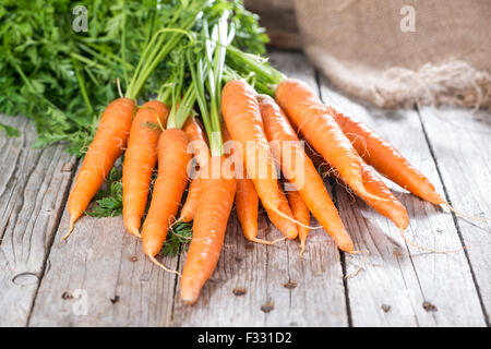 Some fresh Carrots on wooden background (close-up shot) Stock Photo