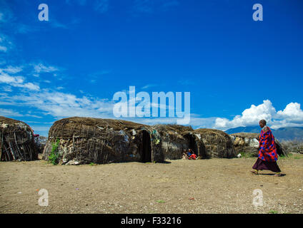 Tanzania, Arusha region, Ngorongoro Conservation Area, maasai cwoman passing in front oh her home Stock Photo