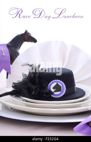 Horse racing Ladies Luncheon fine dining table setting with small black fascinator hat, decorations and champagne. Stock Photo