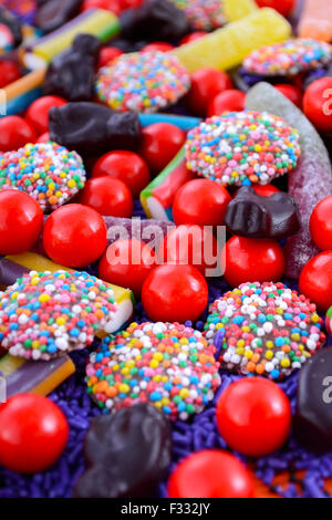 Bright colorful Halloween theme candy background with chocolate freckles, candy worms, orange and purple theme lollies. Stock Photo