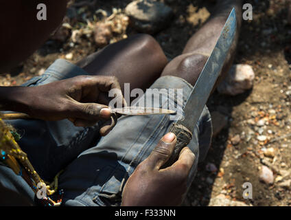 Tanzania, Serengeti Plateau, Lake Eyasi, hadzabe bushman making the arrow for a hunting bow Stock Photo