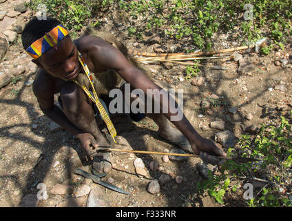 Tanzania, Serengeti Plateau, Lake Eyasi, hadzabe bushman making the arrow for a hunting bow Stock Photo