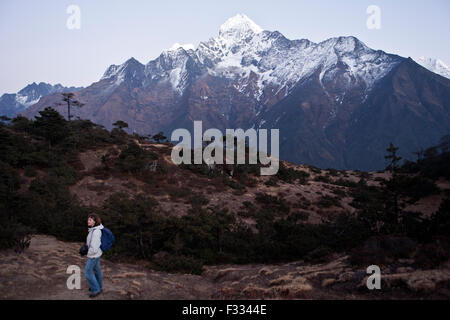 Single traveler against magnificent Thamserku mountain in the Himalaya of eastern Nepal Stock Photo