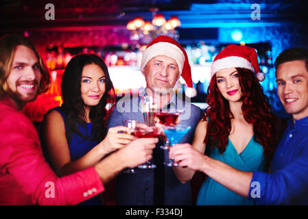 Happy company with drinks cheering up during party in bar Stock Photo