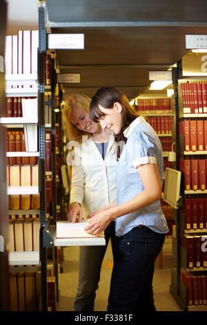 Two students reading a book in library Stock Photo