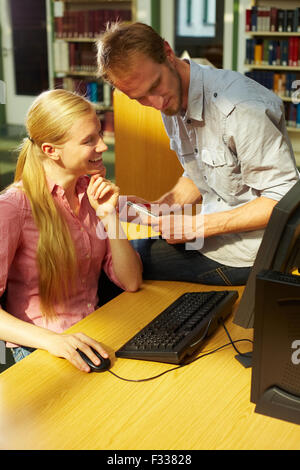 Two students working in library on computers Stock Photo