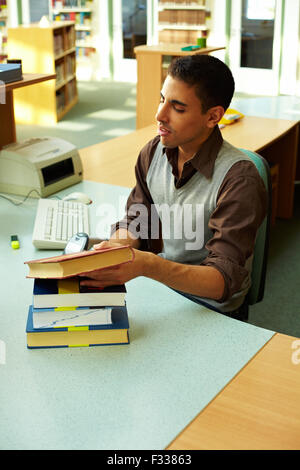 Librarian scanning books at library checkout counter Stock Photo