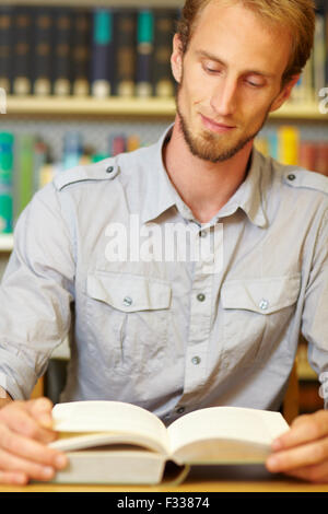 Student reading a book in library archive Stock Photo