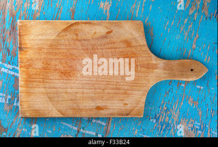 Cutting board on rustic wooden kitchen table as blank copy space for food, cooking and nutrition themes, top view Stock Photo