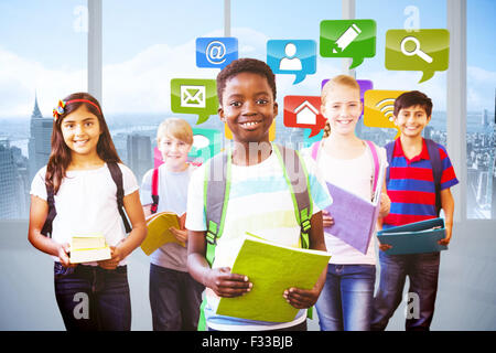 Composite image of smiling little school kids in school corridor Stock Photo