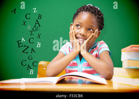 Composite image of pupil sitting at her desk Stock Photo