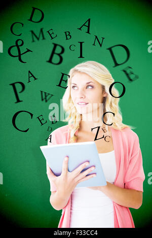 Composite image of young pretty student using tablet pc Stock Photo