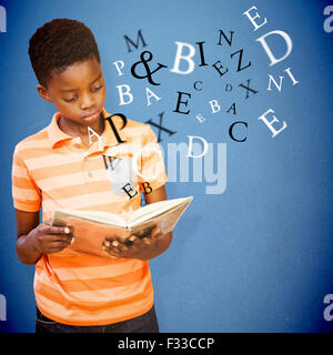 Composite image of cute boy reading book in library Stock Photo