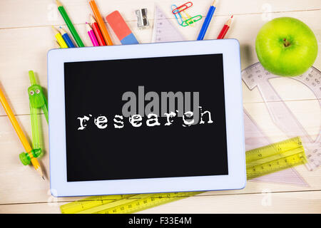 Research against students table with school supplies Stock Photo