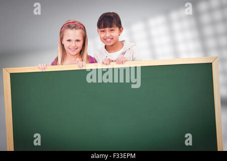 Composite image of girls behind a blank panel Stock Photo