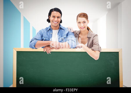 Composite image of couple leaning on blank wall Stock Photo