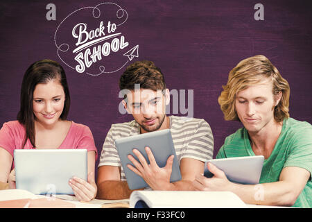 Composite image of college students using digital tablets in library Stock Photo