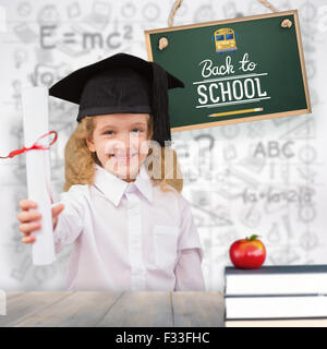 Composite image of smiling schoolgirl with graduation cap and holding her diploma Stock Photo