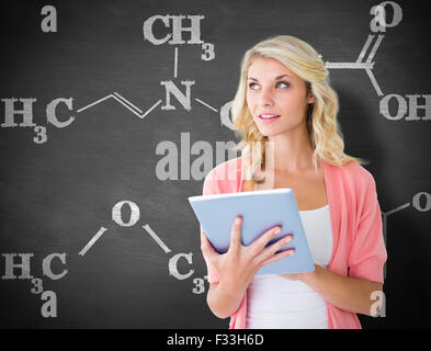 Composite image of young pretty student using tablet pc Stock Photo