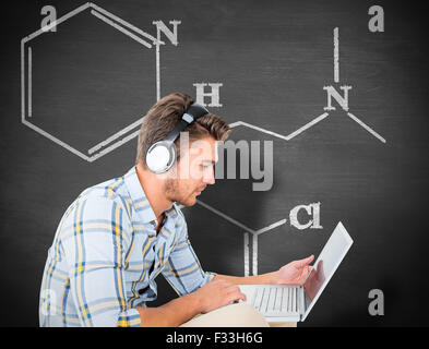 Composite image of young student using laptop Stock Photo