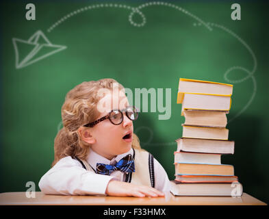 Composite image of surprise pupil looking at books Stock Photo