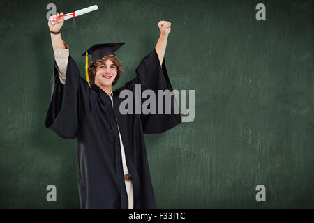 Composite image of male student in graduate robe raising his arms Stock Photo