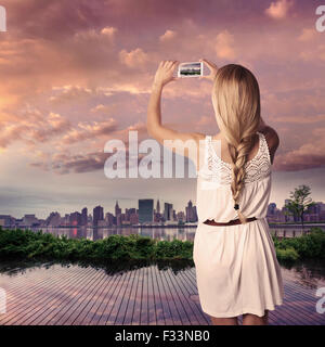 Blond tourist girl taking photo of Manhattan skyline in New York at sunset Photomount Stock Photo