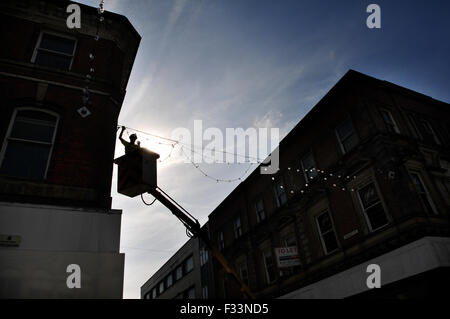 As the town basks in warm Autumnal sunshine Bolton Council put up their Christmas, lights. Stock Photo