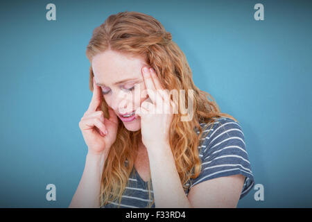 Composite image of upset blonde woman suffering from headache Stock Photo