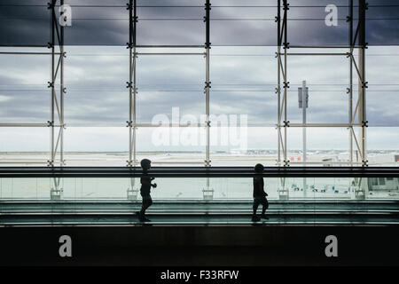 Barcelona, Spain -17 Aug 2015- Silhouette of children walking on a travelator at the Barcelona international airport Stock Photo