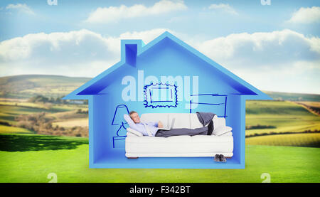 Composite image of portrait of smiling businessman with laptop lying on sofa Stock Photo