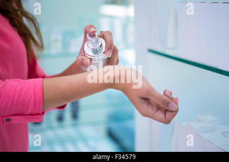 Woman spraying perfume on her wrist Stock Photo
