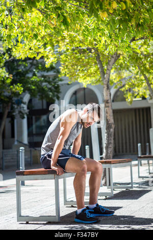 Exhausted athlete resting on a bench Stock Photo